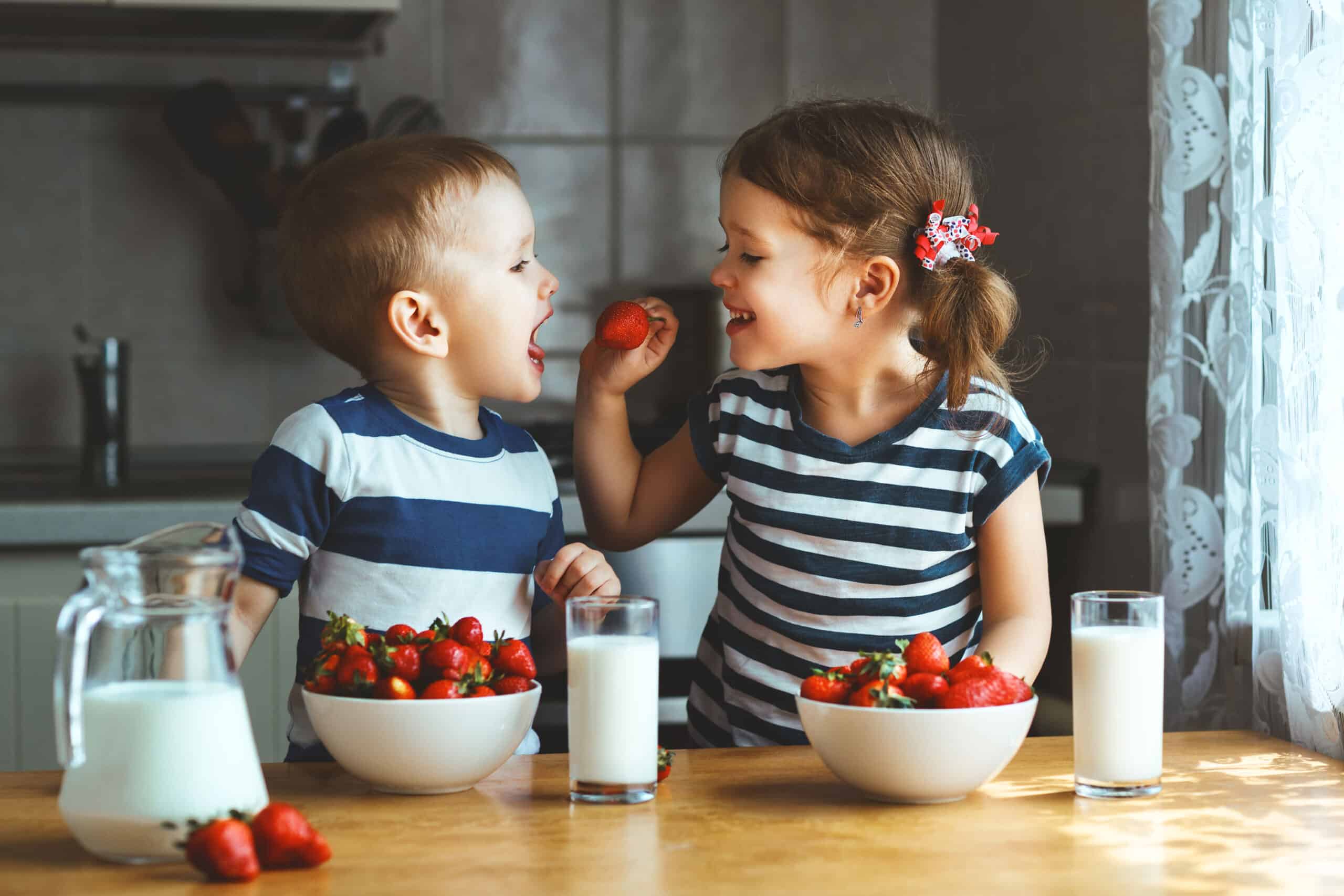 Boy and girl eating strawberries